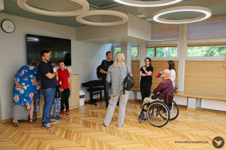 Uczestnicy zajęć stałych rozmawiają razem na sali w Pracowni Kultury Dziesiąta.