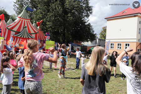 Prowadząca warsztaty stoi na środku kółka. Dzieci ustawione dookoła klaszczą i skaczą.