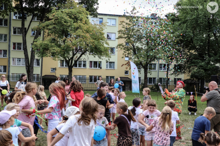 Dzieci tańczą w parach. Śmieją się i wygłupiają. Klaun w czerwonym meloniku wystrzeliwuje w górę kolorowe confetti.