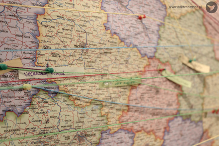 Mapa Polski z pinezkami i przywiązanymi do nich nitkami.