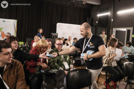 Kierownik programowy Dzielnicowego Domu Kultury Bronowice i organizator TRIYOU Forum rozdaje specjalnie wydanie gry karcianej: Graj w Maki na okrągło.