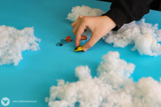 Grafika promująca program zimowych warsztatów artystycznych w Pracowniach Kultury Maki. Na zielonym tle widać padający śnieg. Na dole grafiki znajduje się bałwanek. Stoi na śniegu i ubrany jest w zielony szalik. Ma zamknięte oko, a w ręce trzyma kulę śniegu. Jest bardzo uśmiechnięty. Po prawej stronie grafiki napis: “ZIMA Z KULTURĄ”, pod nim: “PRACOWNIE KULTURY MAKI”. W prawym dolnym rogu szary napis: www.ddkbronowice.pl, obok napisu mały koliber na szarym tle.