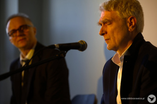 Grafika promująca wydarzenia cykliczne Salonik Artystyczny  w Pracowniach Kultury Dziesiąta. Grafikę stanowi czarno-białe zdjęcie artystów na białym tle. Wokół zdjęcia, na białym tle, czarna ramka . Na samej górze grafiki napis: “KONCERT”. W górnej części, biały napis: “SOKOŁOWSKI&MENET”. W prawym górnym rogu grafiki logotyp Saloniku Artystycznego: żółty napis “SALONIK ARTYSTYCZNY”, a na nim mała grafika fotela i wysokiej lampki oświetlającej napis.  W prawym dolnym rogu, tytuł koncertu: “JEJ PORTRET”. W lewym dolnym rogu napis www.ddkbronowice.pl, obok napisu mały koliber na szarym tle.